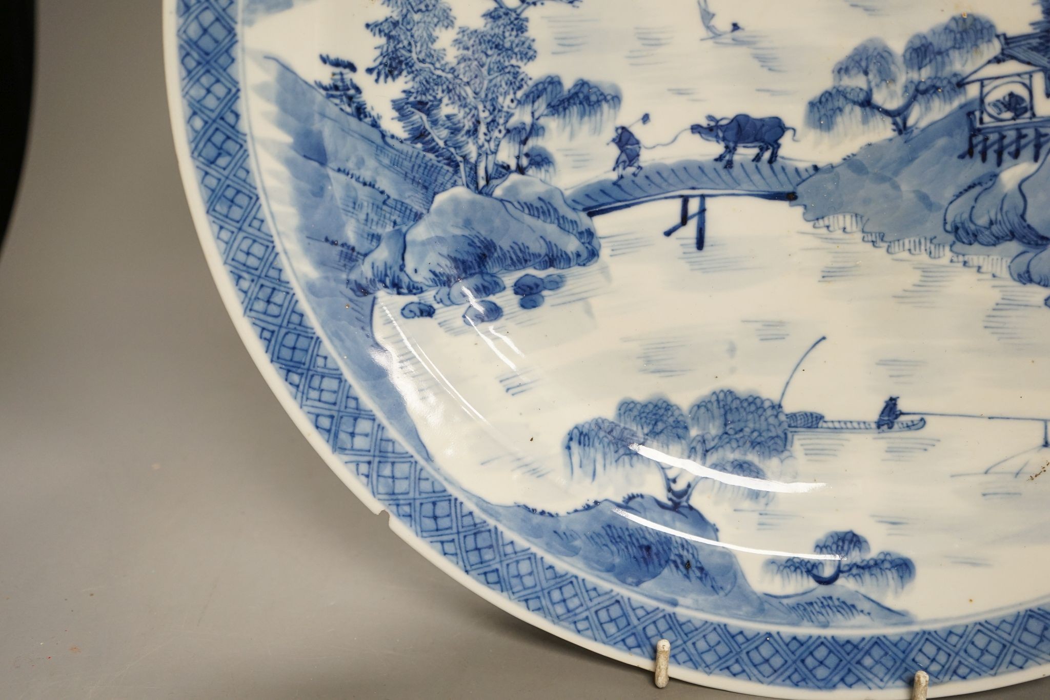 A Chinese blue and white landscape dish, Kangxi mark but 19th century, 36cm